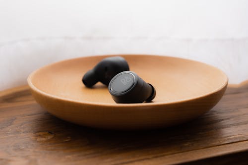 Free Wireless Earbuds On Wooden Bowl Stock Photo