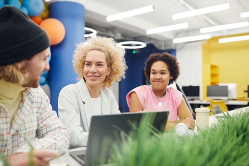 Free A group of colleagues engaged in a friendly discussion in a vibrant modern office setting. Stock Photo