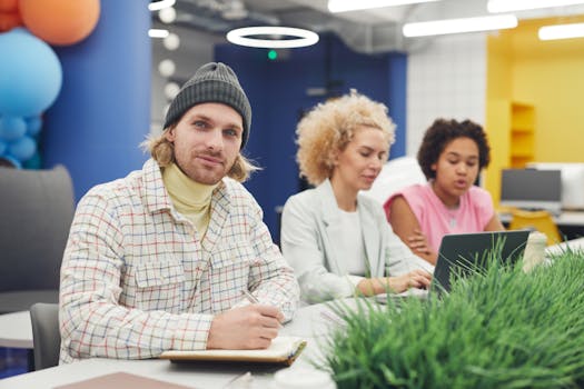 Three diverse coworkers collaborate in a modern, colorful office setting, focusing on creative teamwork and innovation.