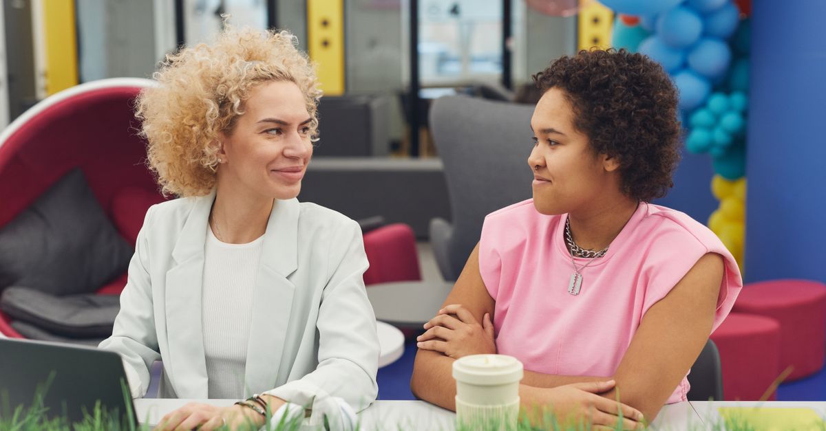 manager and employee in a relaxed conversation, both smiling
