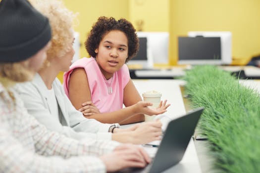 A diverse group of coworkers engaged in discussion at a modern workspace.