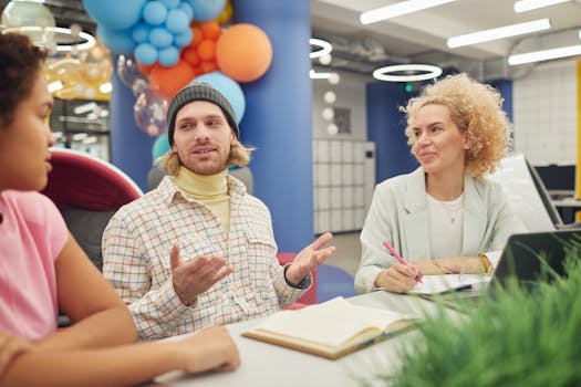 A diverse group of adults discussing ideas in a colorful, modern workspace.