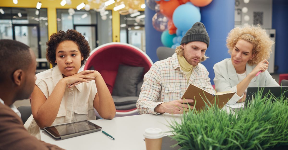 A diverse team collaborates in a bright modern workspace, focusing on creative design projects.