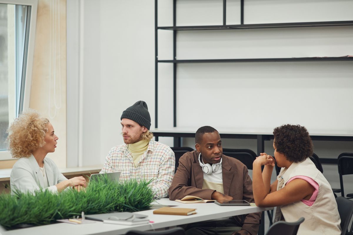 A diverse group of colleagues engaging in a collaborative meeting in a modern office setting.