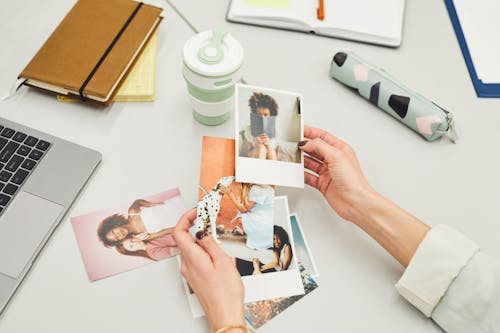 Close-Up Shot of a Person Holding Polaroid Pictures