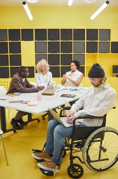 A diverse group of adults having a meeting in a bright office, showcasing inclusivity.