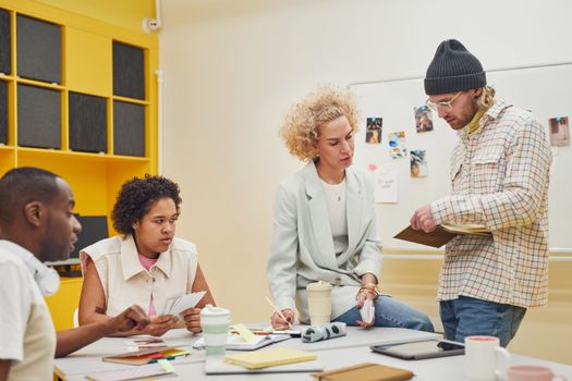 Diverse team brainstorming in a modern office setting, discussing ideas and teamwork.