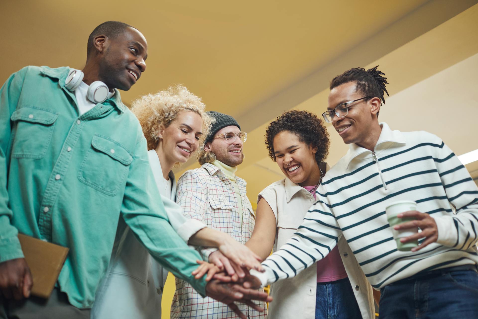 A diverse group of adults sharing a joyful team-building moment indoors.