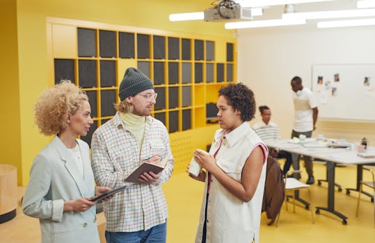 Diverse group of colleagues having a creative discussion in a modern office setting with a bright yellow interior.