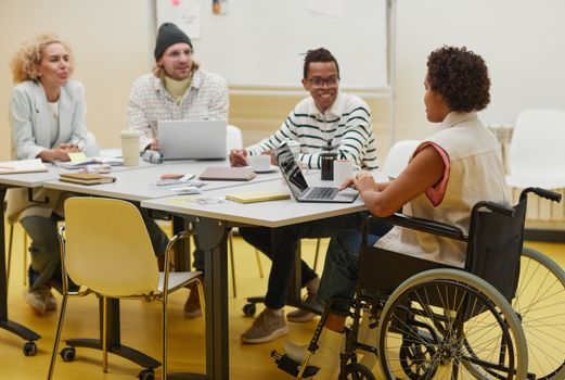 Group of diverse coworkers brainstorming and collaborating in a modern office setting.