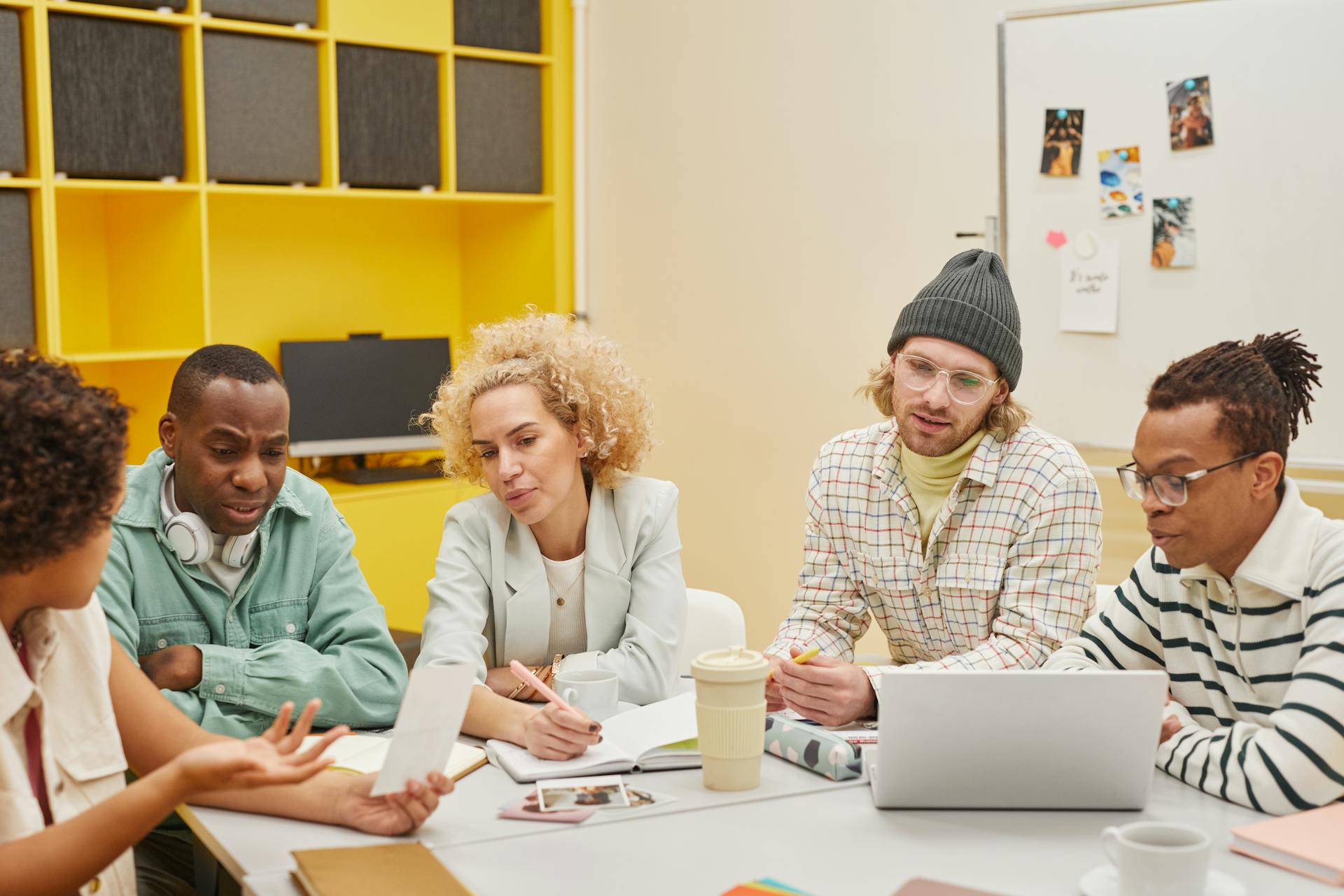 A group of diverse coworkers engaged in a brainstorming session in a bright, modern office setting.