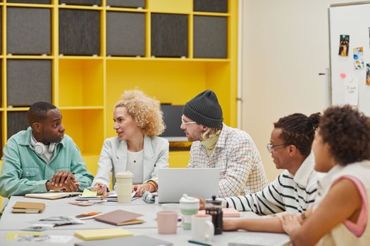 A diverse group of colleagues collaborating in a modern office setting. Ideal for promoting teamwork and inclusivity.