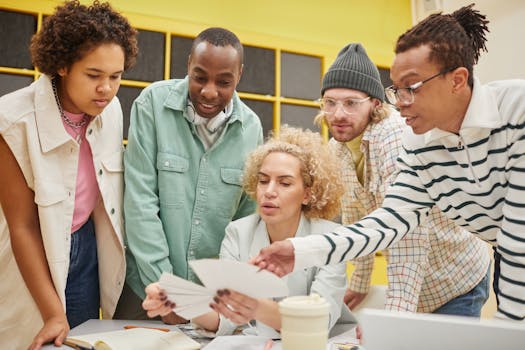 A group of diverse coworkers engaged in a collaborative meeting indoors, promoting teamwork and cooperation.