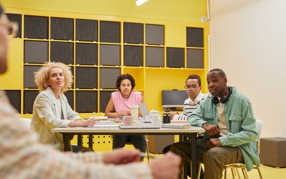 A diverse group of colleagues collaborating in a brightly lit modern office space.