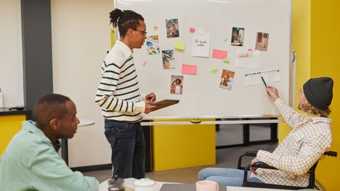 Team discussion around a whiteboard with diverse participants planning a project.