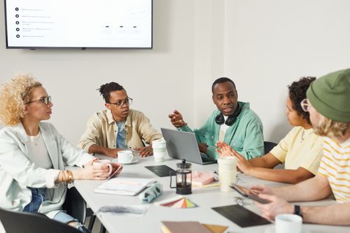 Free A diverse group of professionals engaged in a team meeting in a modern office setting. Stock Photo