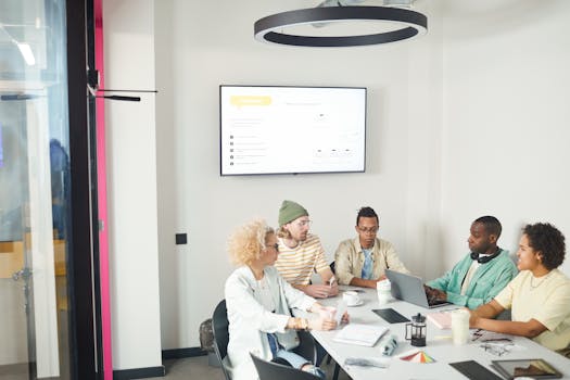 Group of diverse coworkers in discussion during a business meeting in a modern office setting.