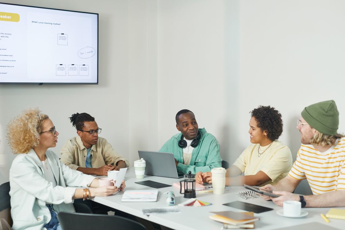 A small group of colleagues collaborating in a compact office, representing a team under 200 employees