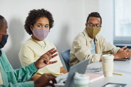 Free Diverse coworkers in a masked meeting, engaging in a collaborative office setting. Stock Photo