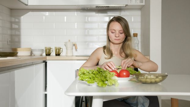 Woman in Brown Tank Top Sitting on Kitchen Table With Vegetable on Top