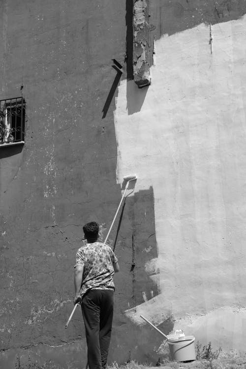 Foto profissional grátis de branco e preto, homem, parede de concreto