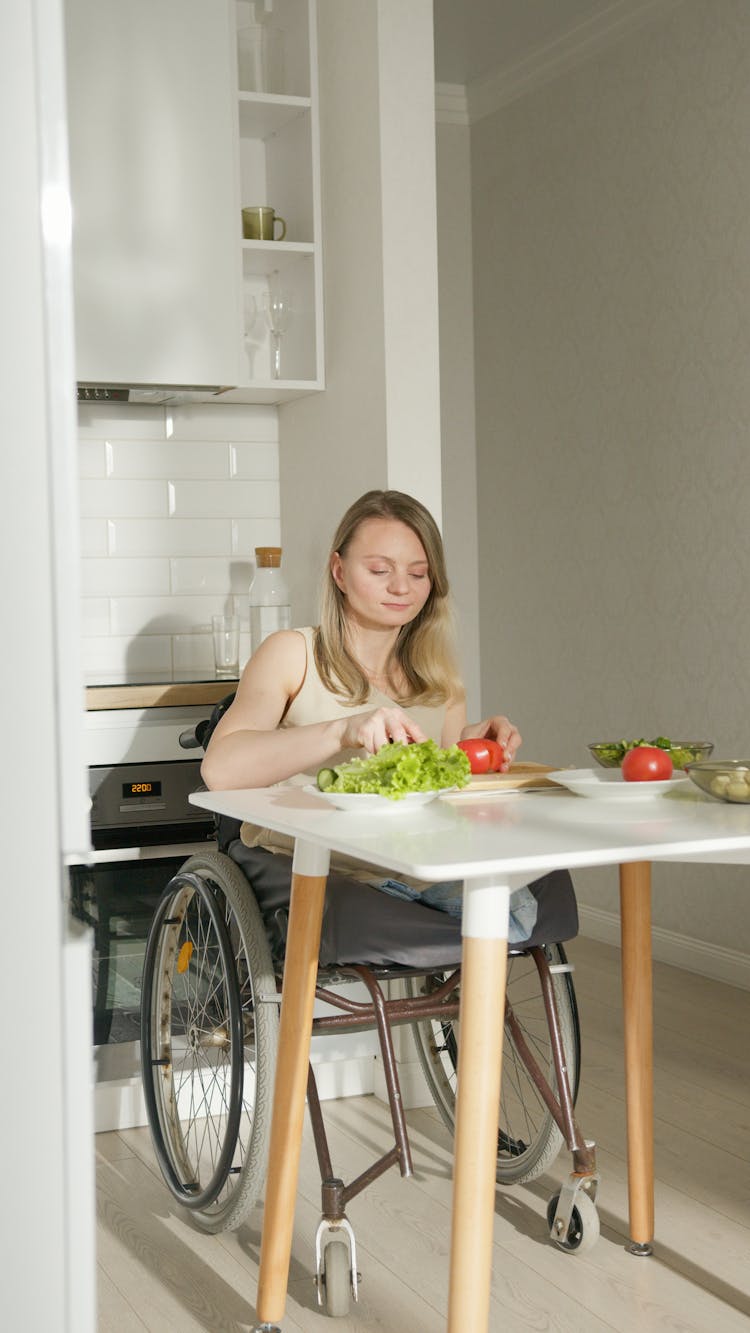 A Woman Cutting Vegetables In The Kitchen