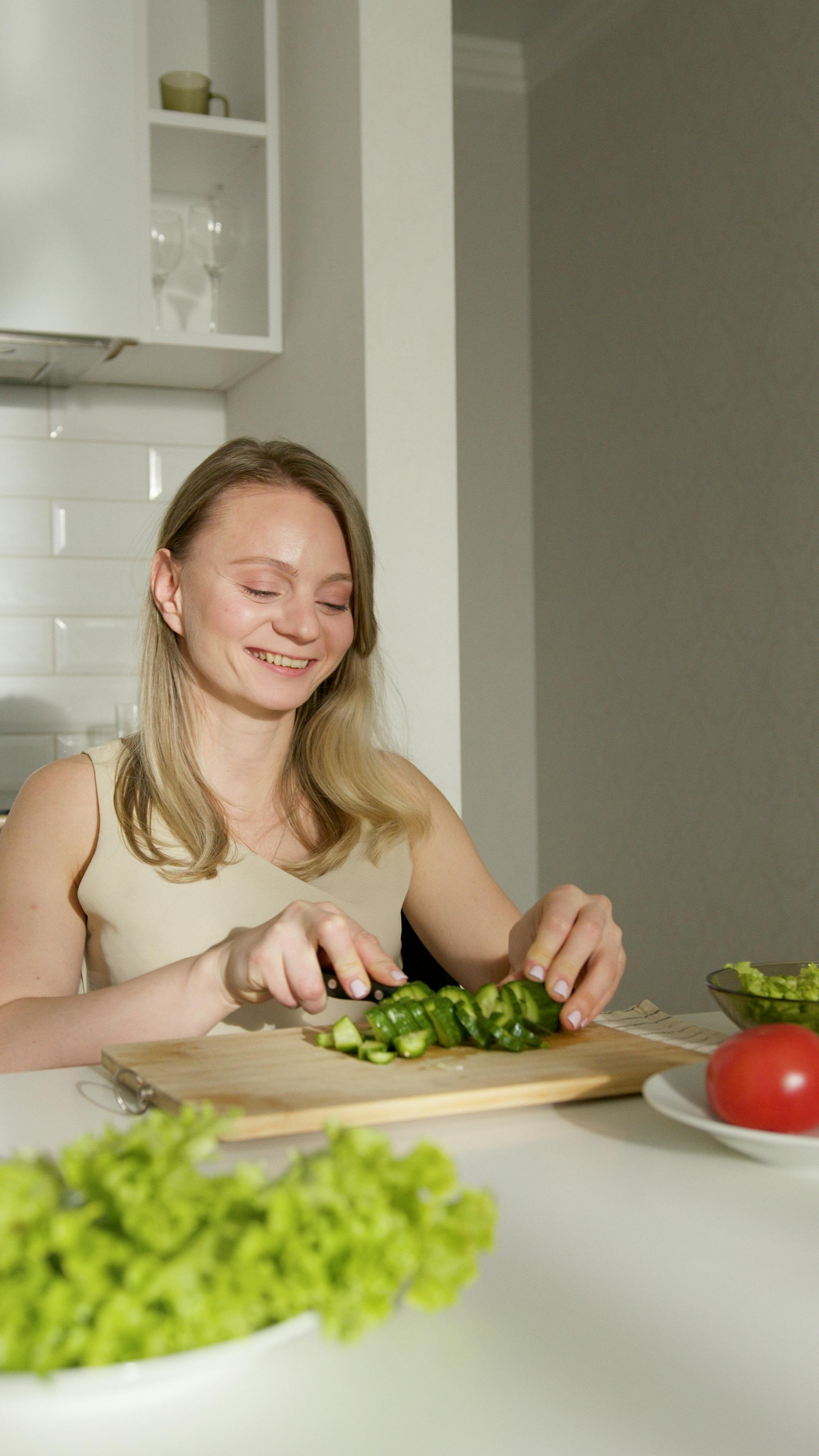 a woman cutting vegetables in the kitchen