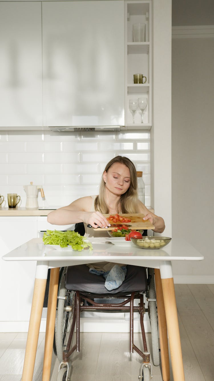 A Woman Cutting Vegetables On The Table