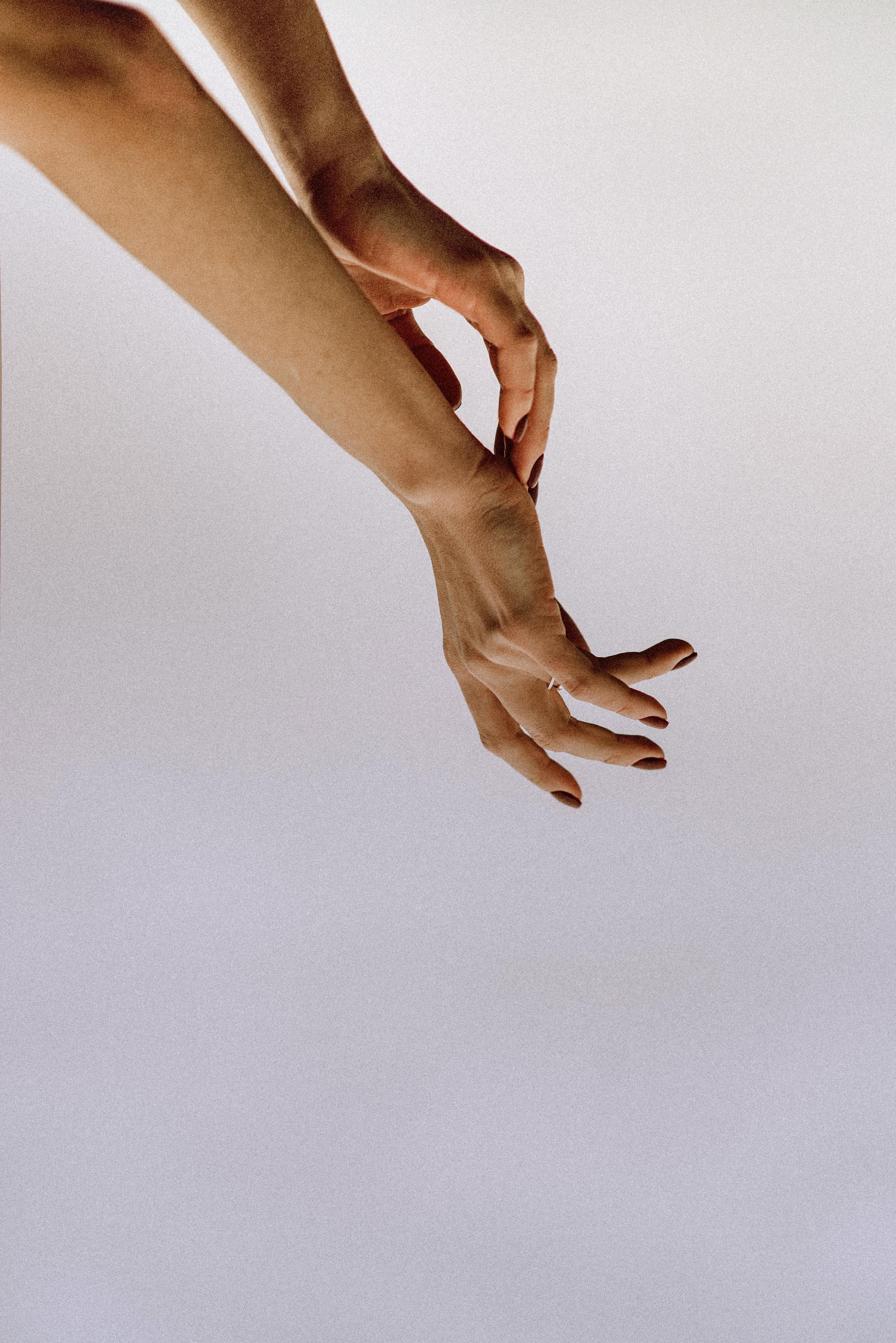 Elegant human hands gracefully posed against a minimalist white background.