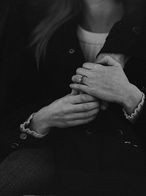 Grayscale Photo of Man and Woman Holding Hands