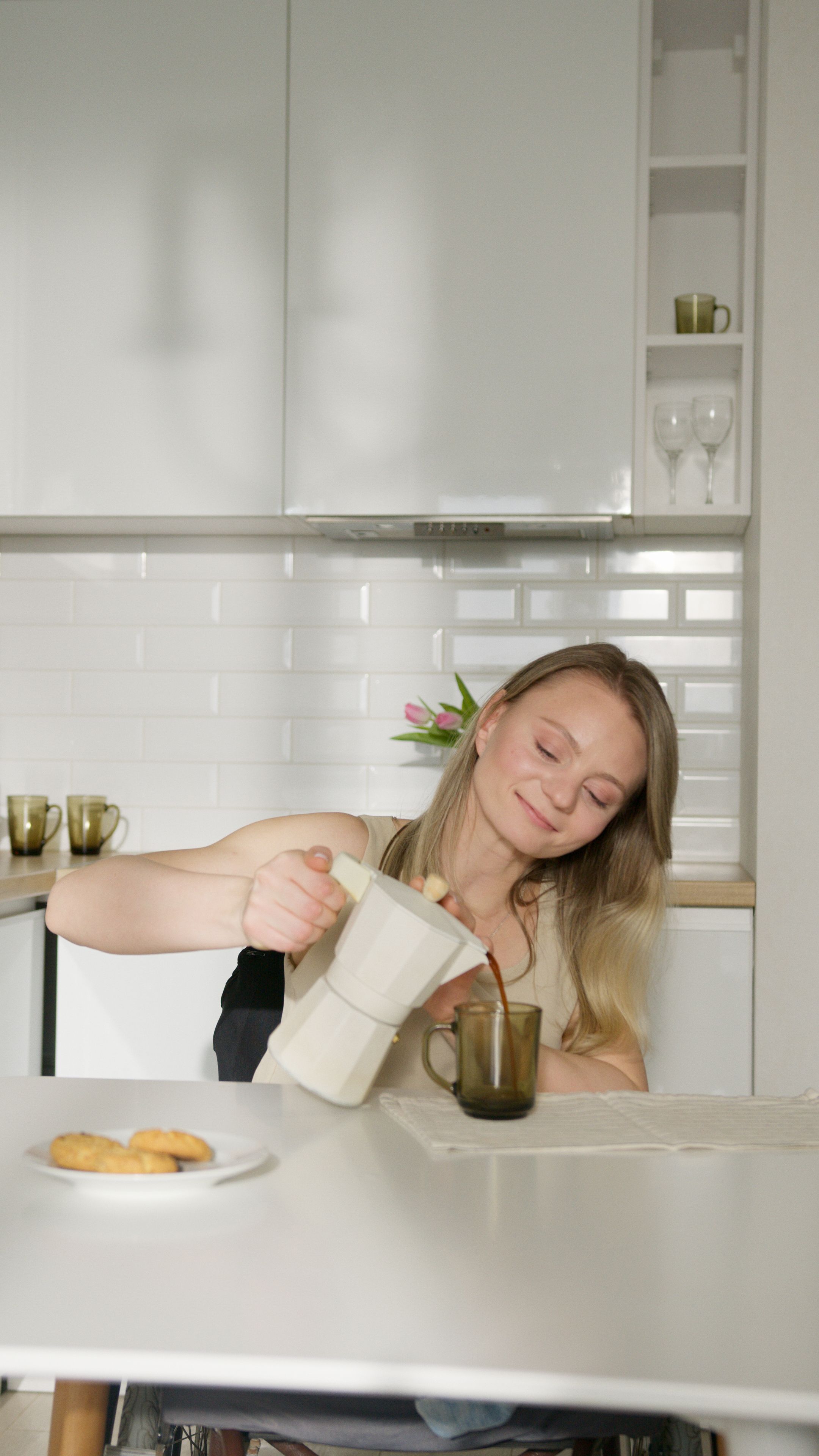 Woman in wheelchair preparing coffee at home, promoting independence.
