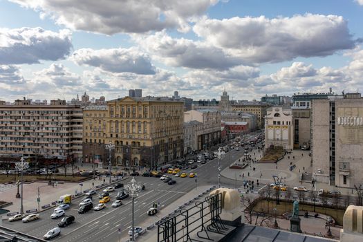 Aerial view of bustling Moscow city with traffic under a cloudy sky, showcasing historic architecture.