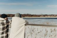 Person in White Hoodie Standing on Snow Covered Ground