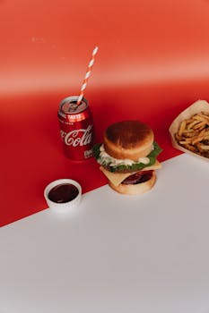 A delicious cheeseburger with fries and soda against a vibrant backdrop, perfect for fast food themes.