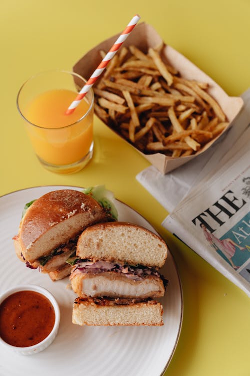 Free Burger and Fries on White Plate Beside Orange Juice Stock Photo