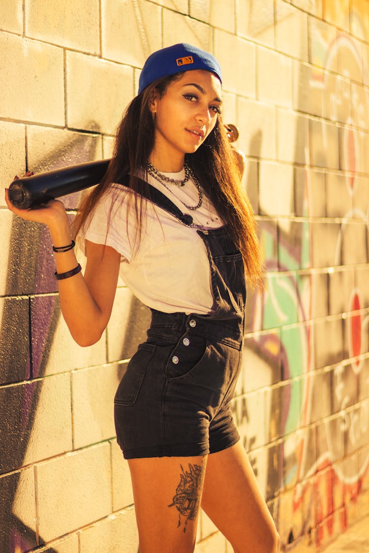 Woman Holding A Baseball Bat Near A Wall With Graffiti