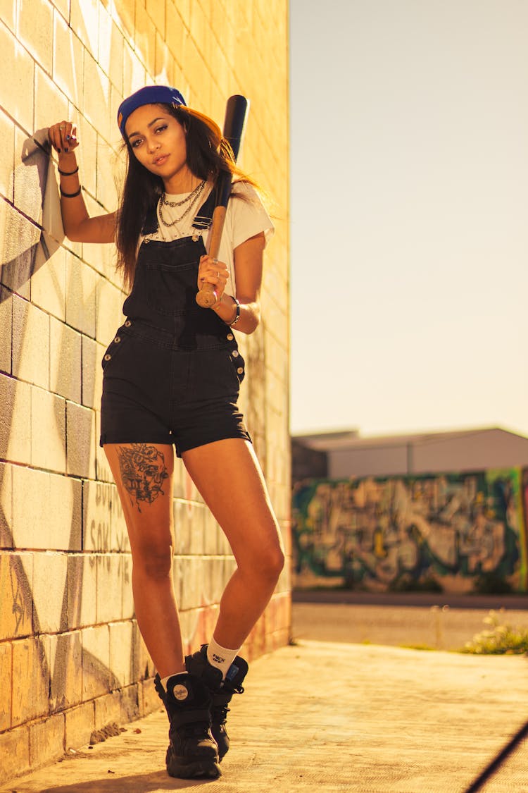 Woman Holding A Baseball Bat Leaning On The Wall