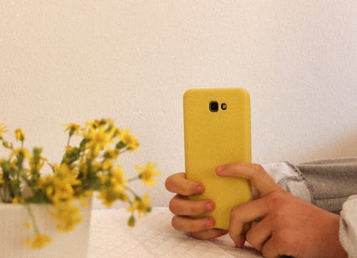 Close-Up View of a Person Holding Yellow Cellphone Case