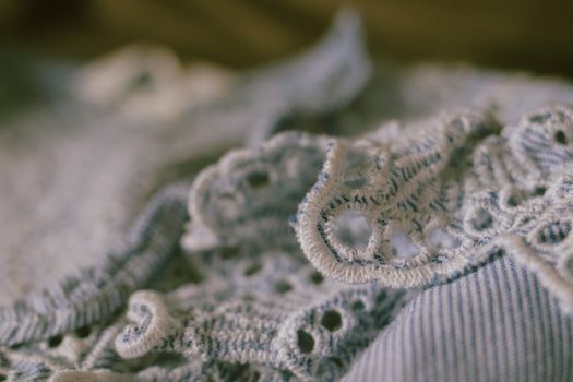 Intricate close-up of blue floral lace fabric showcasing delicate details and fine texture.