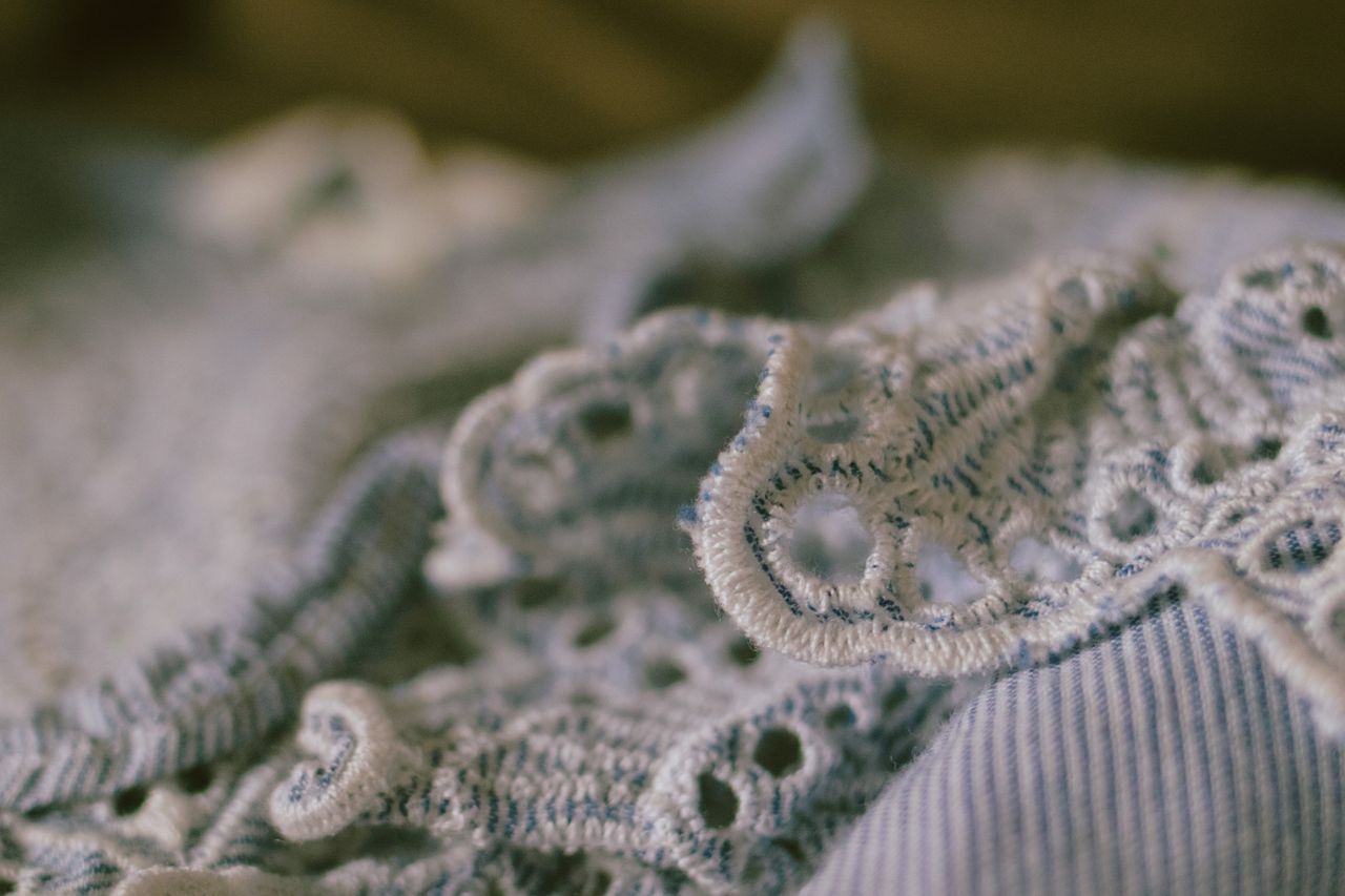 intricate close up of blue floral lace fabric showcasing delicate deta