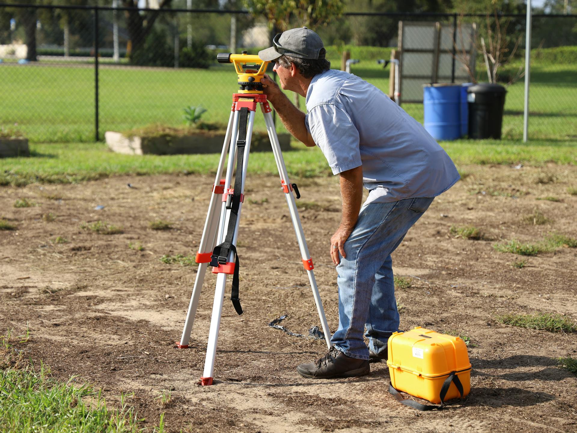 A land surveyor at work using equipment on a field in Tavares, Florida.