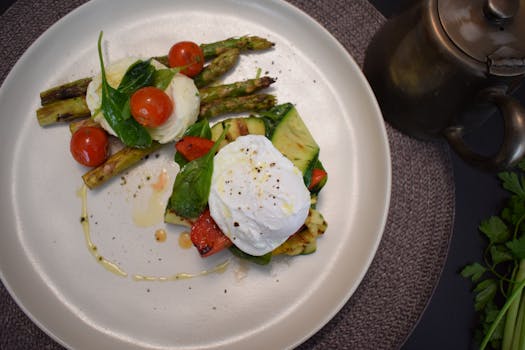 Appetizing breakfast with poached egg, asparagus, and vegetables on a ceramic plate.