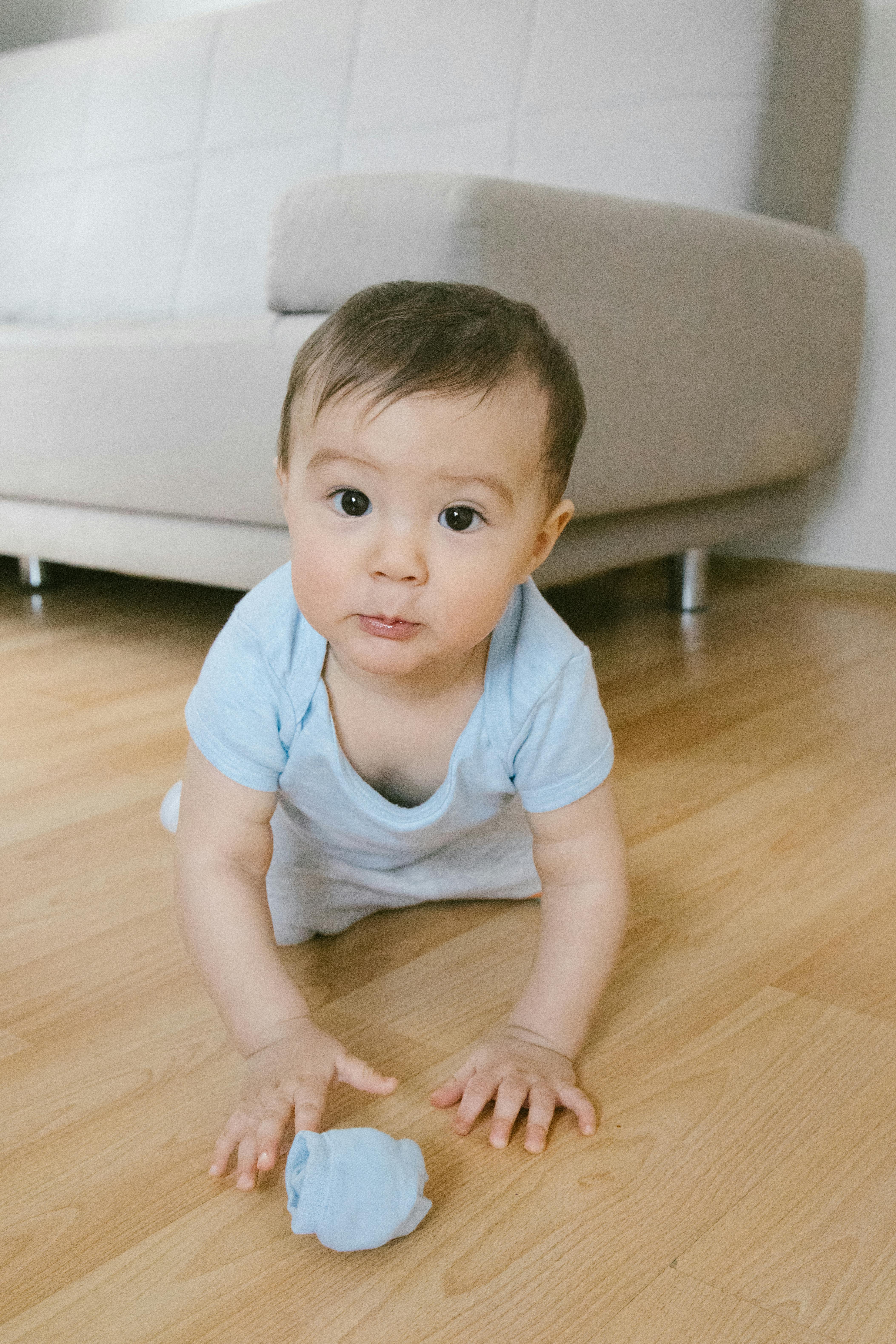 toddler crawling on a wooden floor