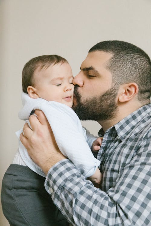 Photo of a Father Kissing His Child