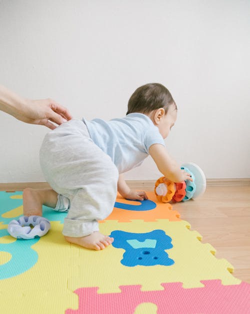 Free Baby Crawling on Puzzle Mat Stock Photo