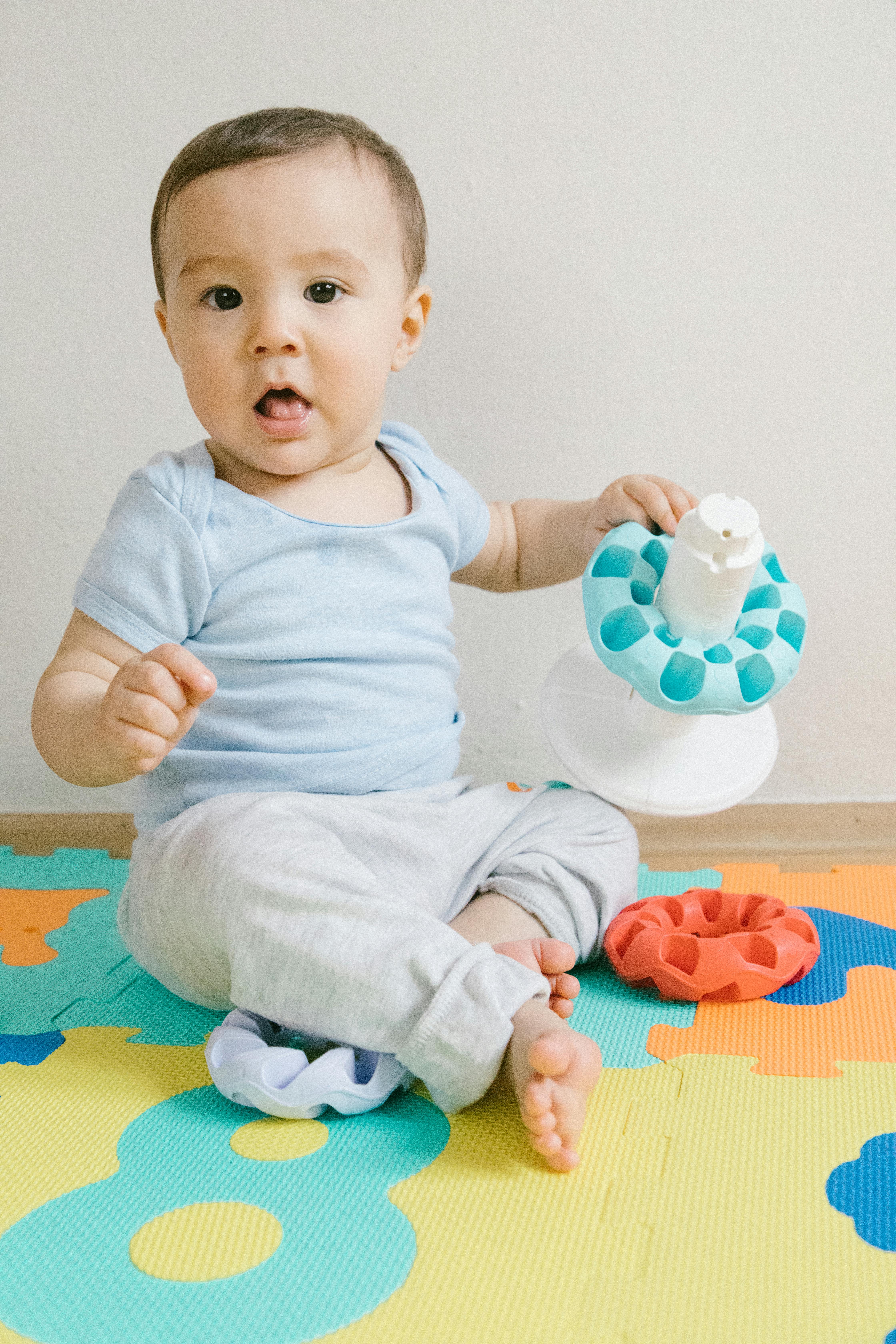 baby sitting on a colorful puzzle mat