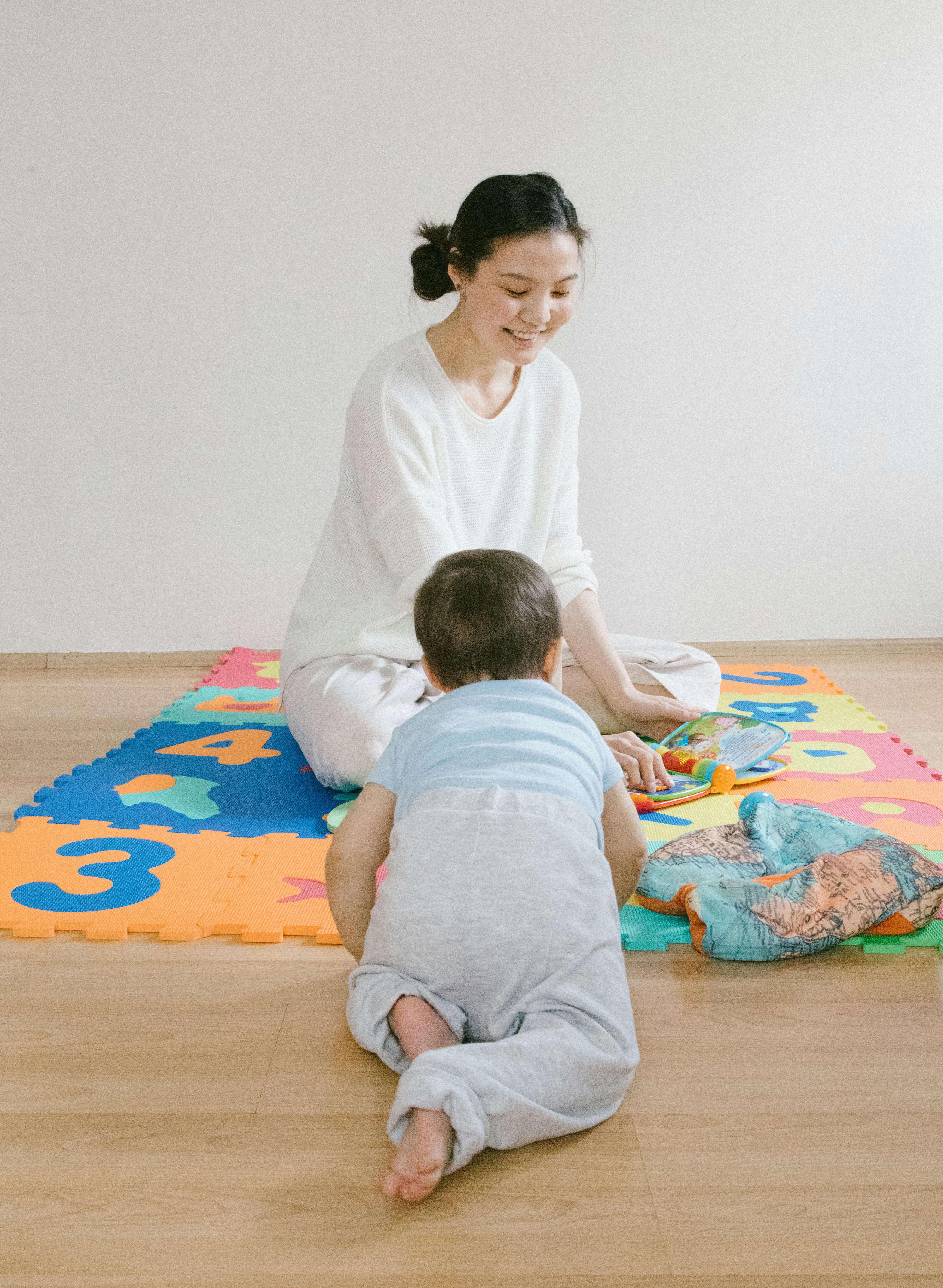 child playing with mother on the puzzle mat