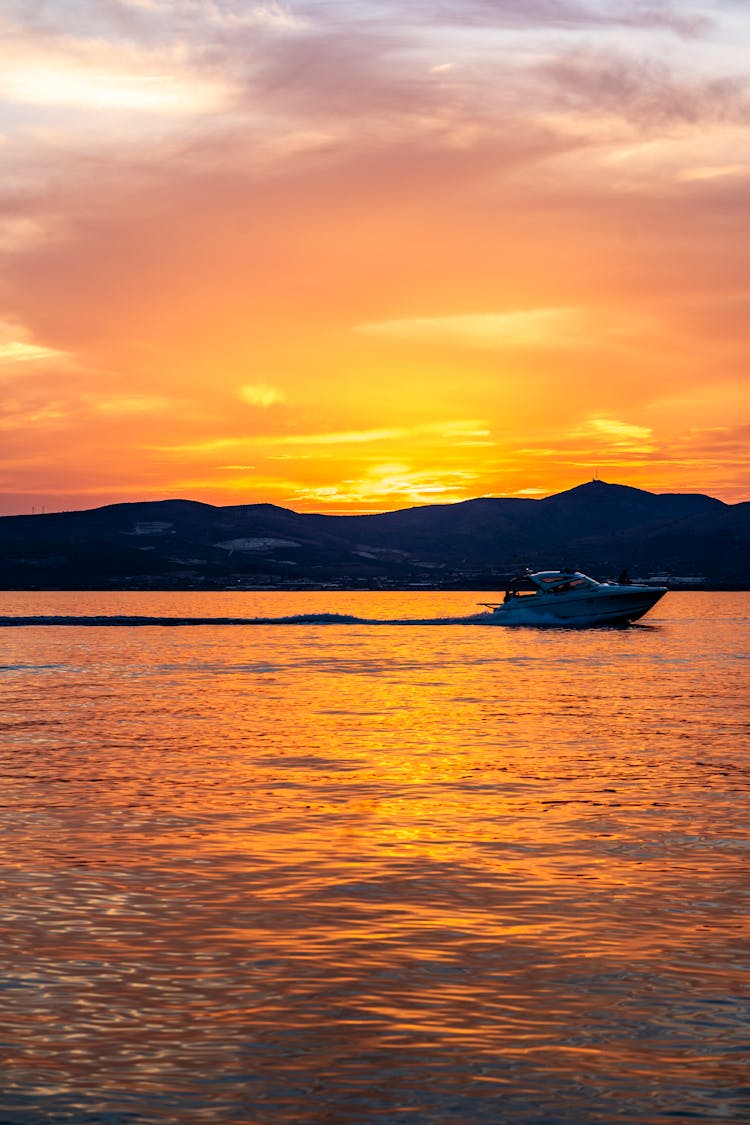 Silhouette Of Speedboat On Sea During Sunset