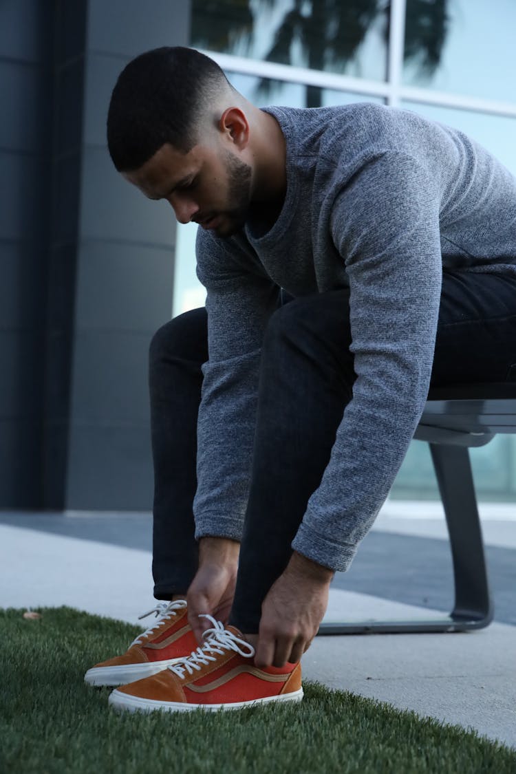 Man Wearing Gray Long Sleeve Shirt Putting On Shoes