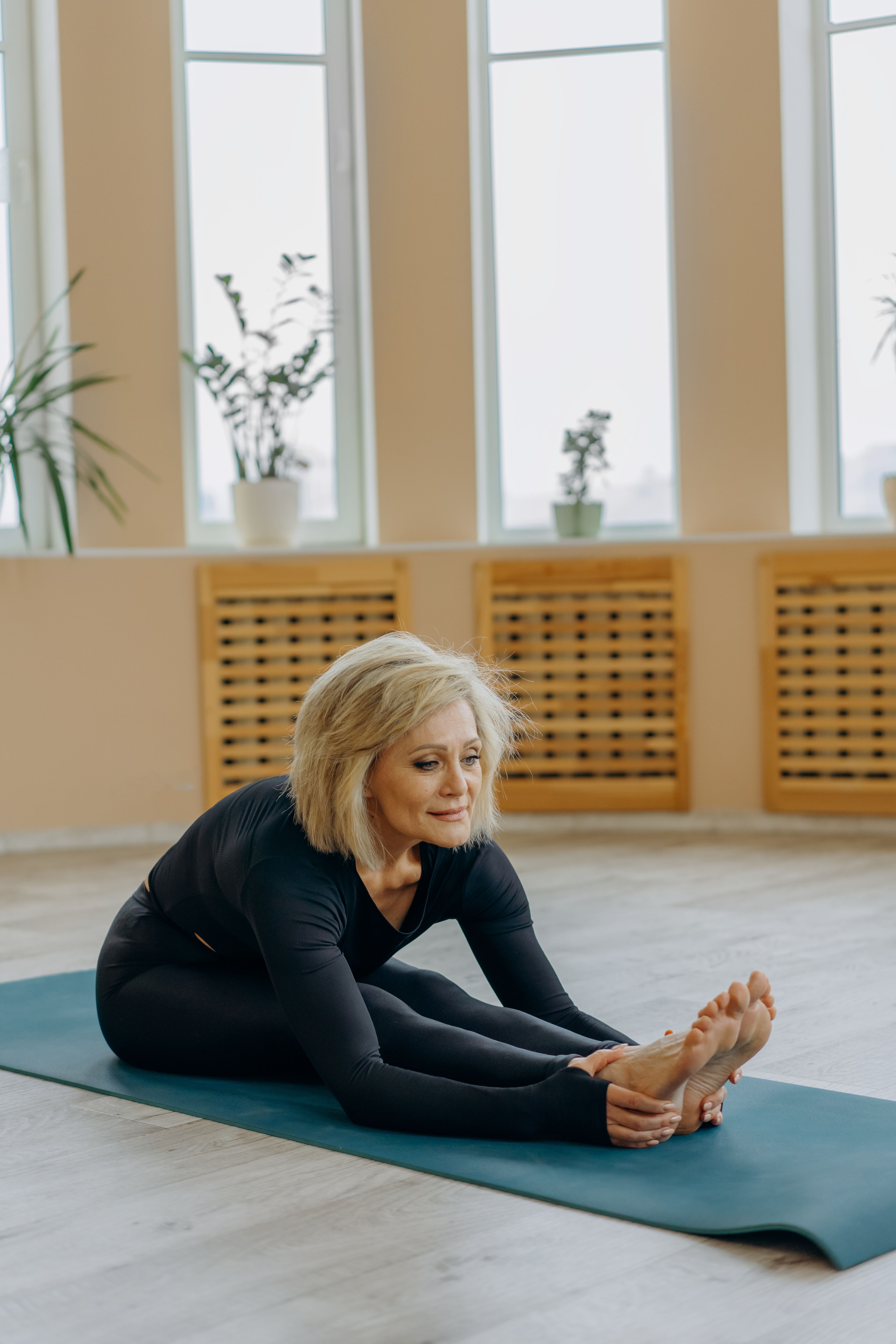 Photo of a Woman Stretching on a Yoga Mat · Free Stock Photo